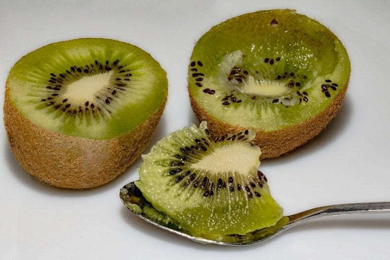 Kiwis cortados por la mitad mostrando la pulpa verde y las semillas
