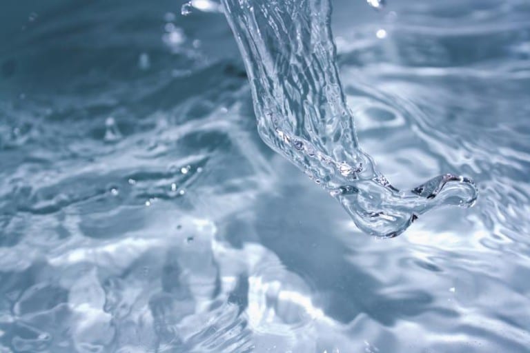 Agua de riego cayendo sobre el suelo del jardín