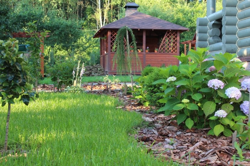 Diseño de un jardín de estilo cottage inglés con macizos densos junto a un camino