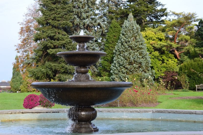 Fuente de piedra instalada en un jardín ajardinado