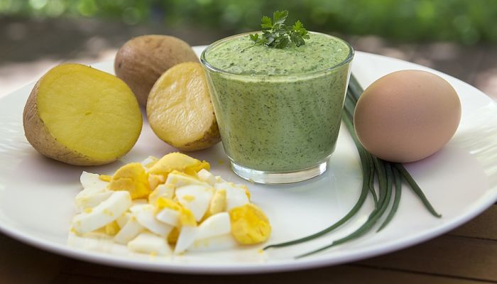 Salsa verde de hierbas servida con patata cocida y huevo duro