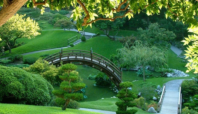 Jardín japonés con rocas, grava rastrillada y arbustos podados