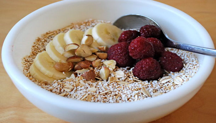 Cuenco de desayuno con amaranto reventado, avena, plátano, almendras y frambuesas