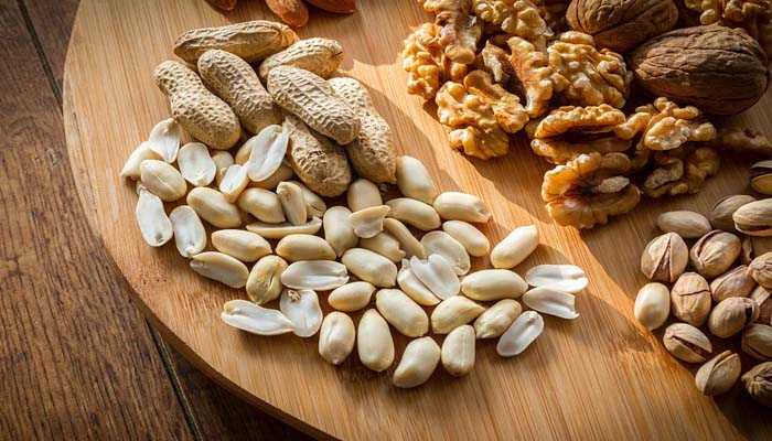 Cacahuetes, nueces y pistachos sobre una tabla de cortar